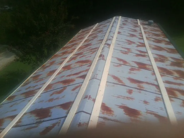 Rusted metal roof panels with new wood purlins before replacement — Storm Damage Roof Repair in North Kingstown by Roofing Brothers