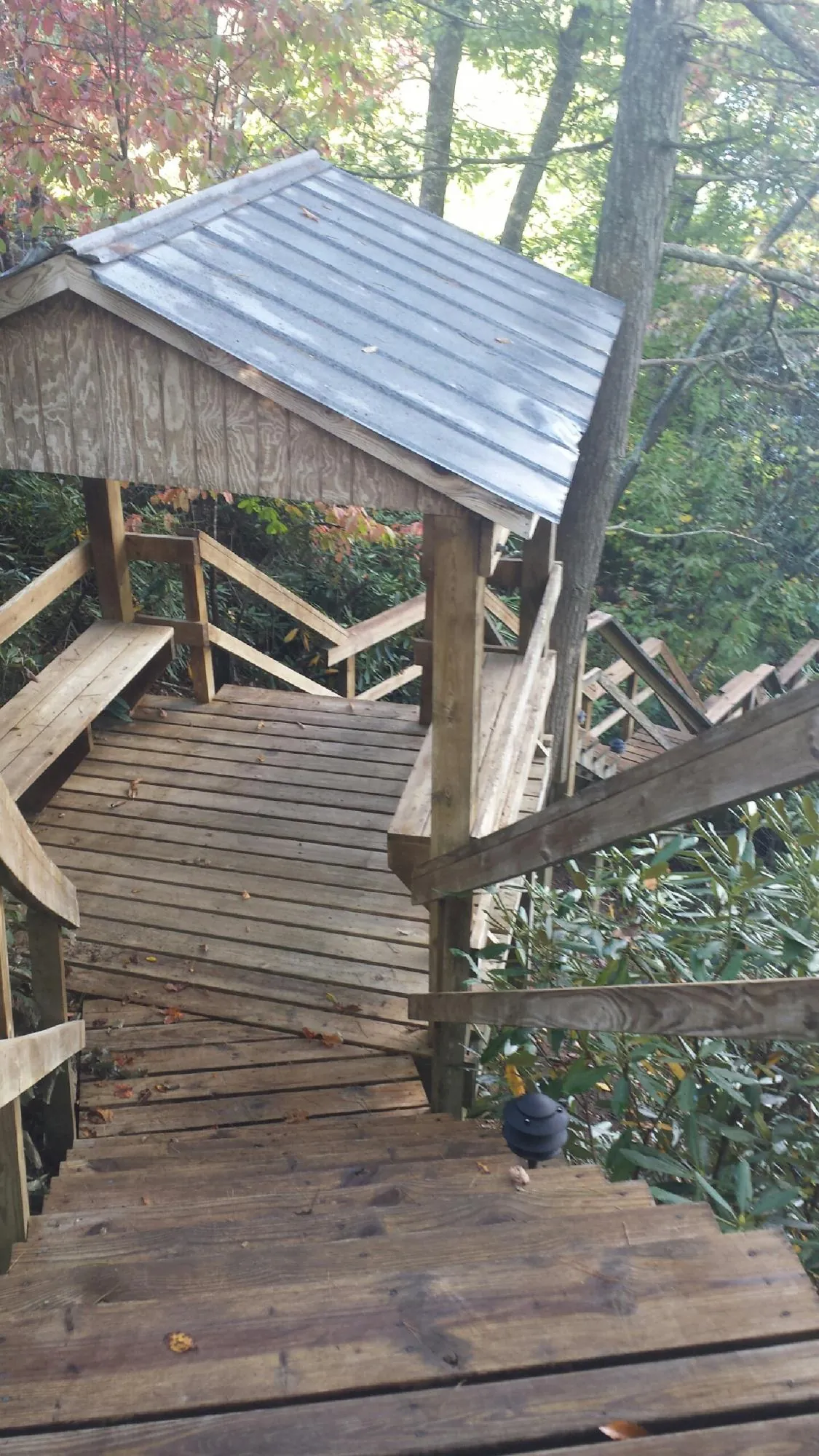 Metal roofed shelter over wooden steps on a wooded walkway — Skylight Repair & Installation work by our crew in North Kingstown