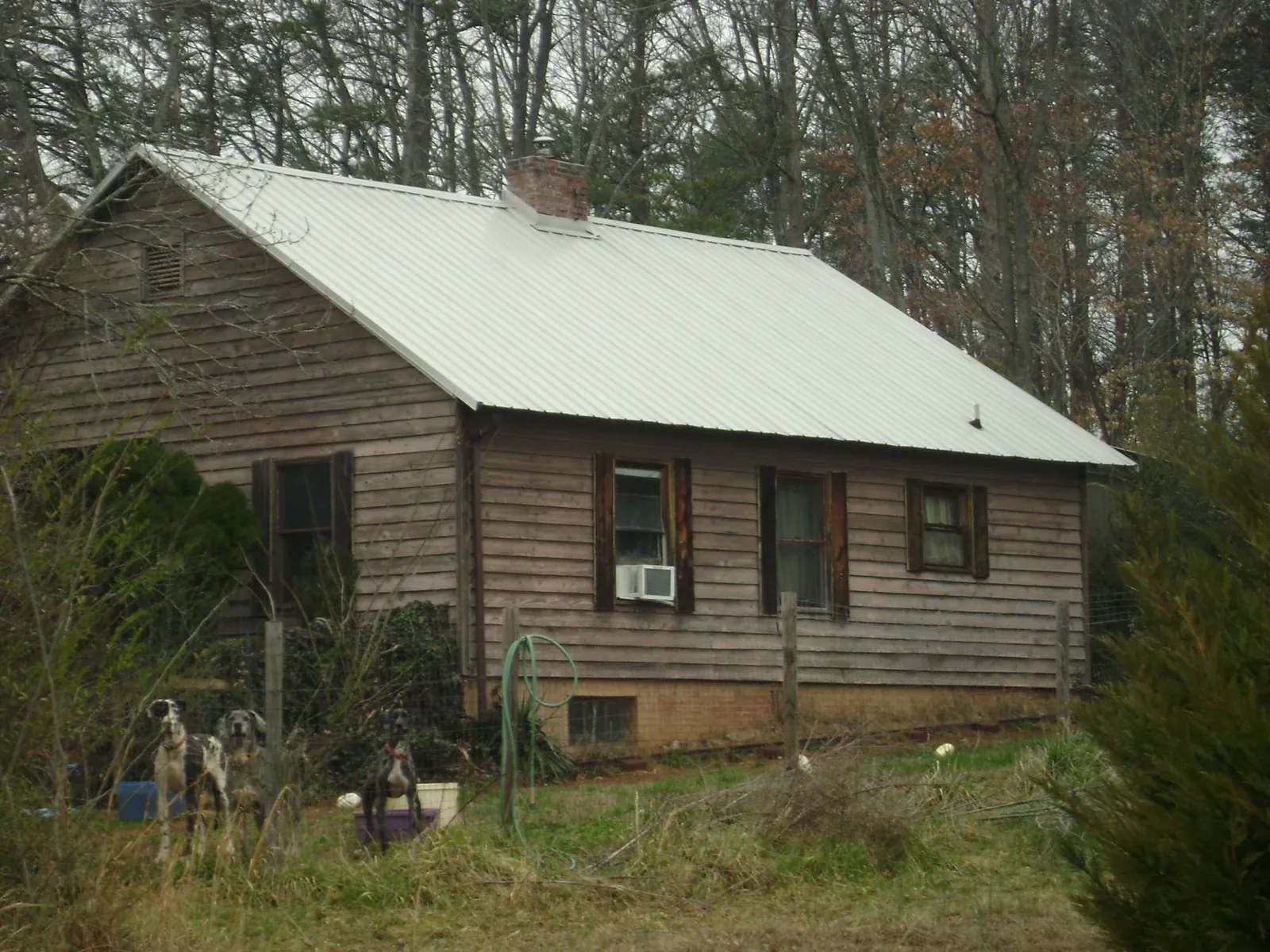 White metal roof on an old wood sided farmhouse, from a Metal Roof Installation job in North Kingstown